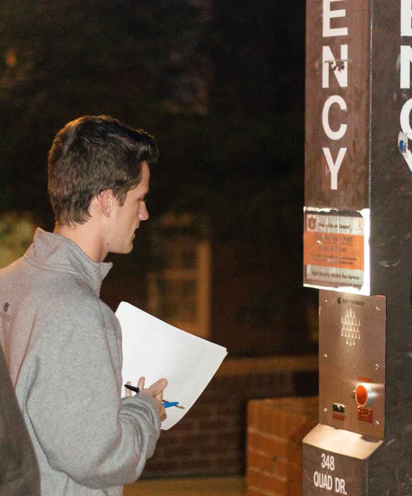 A student testing an emergency phone during the student safety walk